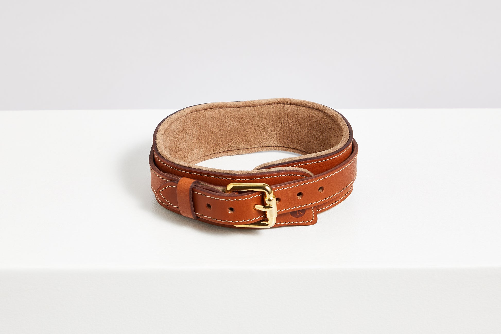 Buckle detail on tan leather collar with cream suede lining