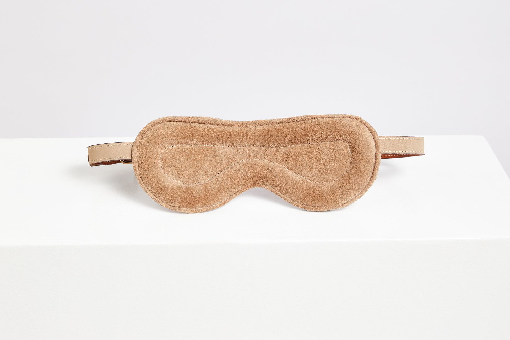 Reverse side of the leather blindfold showing suede lining and padded rear.