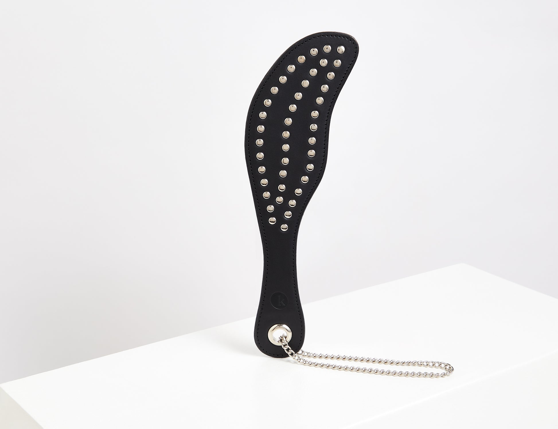 Black leather studded spanking paddle with silver stud detail and wrist chain